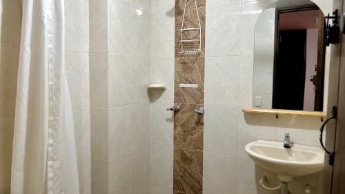 a bathroom with a sink and a toilet and a mirror at Real Dream Hostel in San Gil