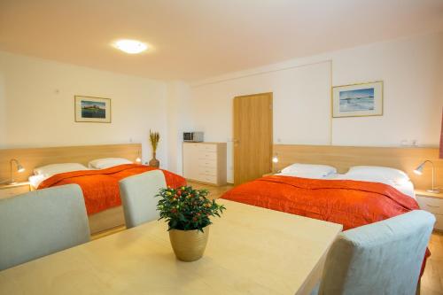 a bedroom with two beds and a table with a plant at Apartments Benedičič in Bled