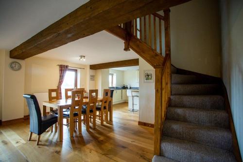 a dining room and kitchen with a table and a staircase at Pentre Fawr in Llanddewi Ystradenny