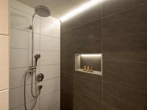 a bathroom with a shower with a shower head at Apartment Filzenkogel in Schwendau