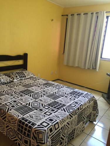 a bedroom with a bed with a black and white comforter at Apartamento em Meireles, Praia de Iracema in Fortaleza
