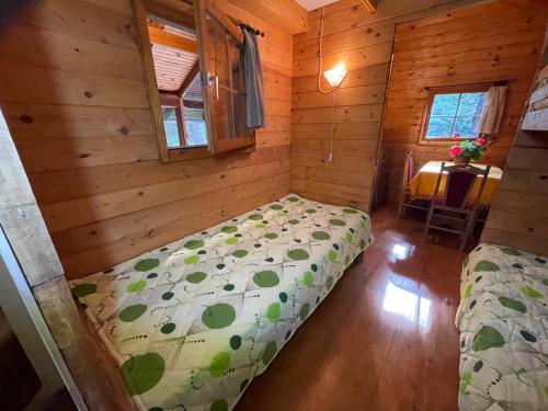a bedroom with a bed in a wooden cabin at Čarobna koliba M&M in Čortanovci