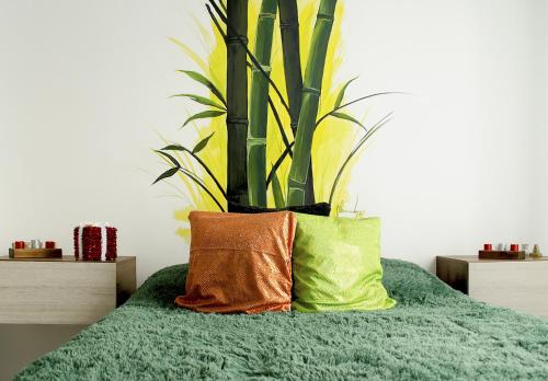 - un lit vert avec deux oreillers et une plante dans l'établissement Cálido apartaestudio en La Castellana, à Armenia