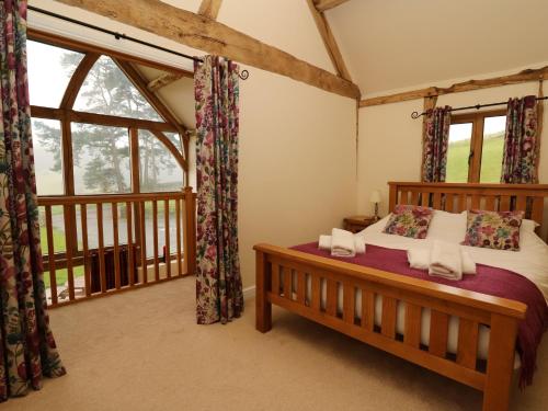 a bedroom with a bed and a large window at The Hayloft in Knighton
