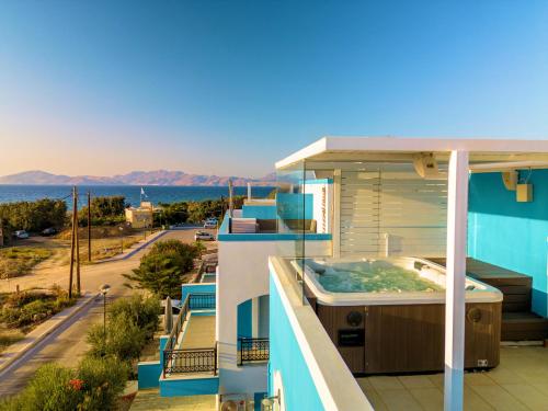 マスティハリにあるSeabreeze Villa - with Jacuzzi & heated poolのホットタブ付きのバルコニーが備わる家です。