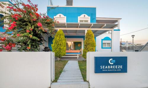 una casa con una señal azul delante de ella en Seabreeze Villa - with Jacuzzi & heated pool, en Mastichari