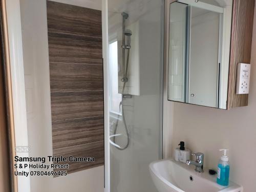 a bathroom with a sink and a mirror at 149 Holiday Resort Unity 3 bedroom passes included in Brean