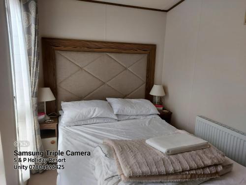 a bedroom with a bed with white sheets and pillows at 149 Holiday Resort Unity 3 bedroom passes included in Brean