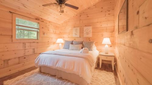 a bedroom with a bed in a wooden cabin at Affordable cabin that sleeps 8 K beds & fire pit in Cosby
