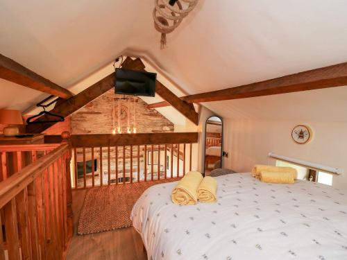 a bedroom with a bed on a balcony at Tegfan Barn in Pant-y-dwr