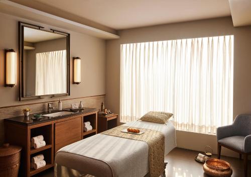 a bathroom with a bed and a sink and a mirror at Taj City Centre New Town, Kolkata in Kolkata