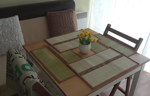 a table with a vase of flowers on top of it at Cozy apartment in the hart of the city in Varna City