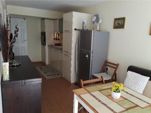 a kitchen with a refrigerator and a table in a room at Cozy apartment in the hart of the city in Varna City