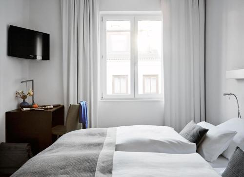 a white bedroom with a bed and a window at Wedina Budget in Hamburg