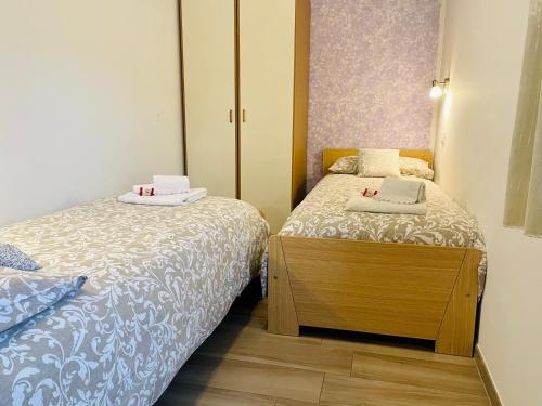 レーヴィコ・テルメにあるAppartamento Verdebleu - Lago e Termeの小さなベッドルーム(ベッド2台、キャビネット付)