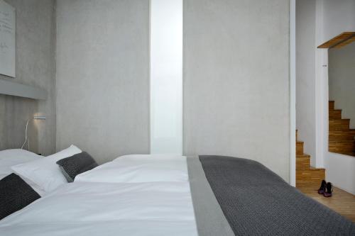 a bedroom with a large white bed and a staircase at Wedina Budget in Hamburg