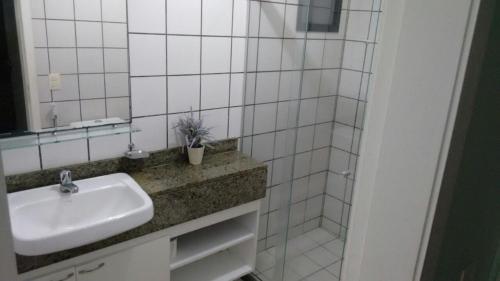 a white bathroom with a sink and a mirror at Apartamento em Meireles, Praia de Iracema in Fortaleza