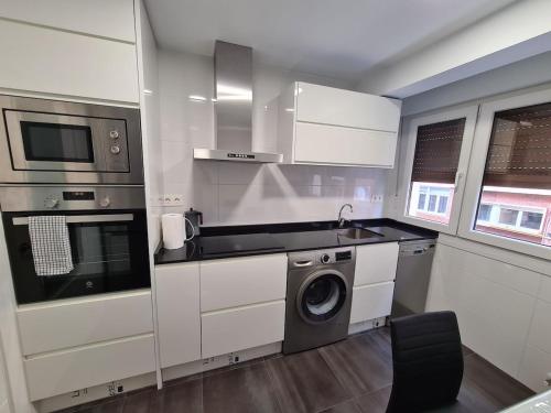 Il comprend une cuisine équipée d'un lave-linge, d'un évier et d'un lave-vaisselle. dans l'établissement 124A Apartamento moderno 3 habitaciones, à Gijón