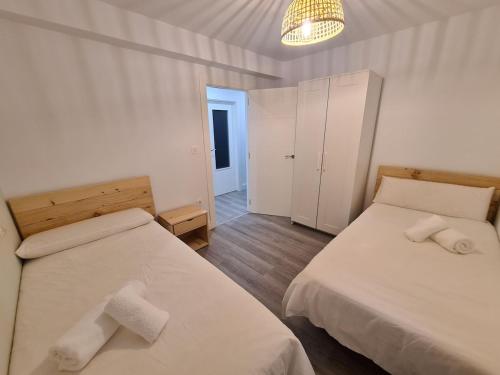 een slaapkamer met 2 bedden en handdoeken bij 124A Apartamento moderno 3 habitaciones in Gijón