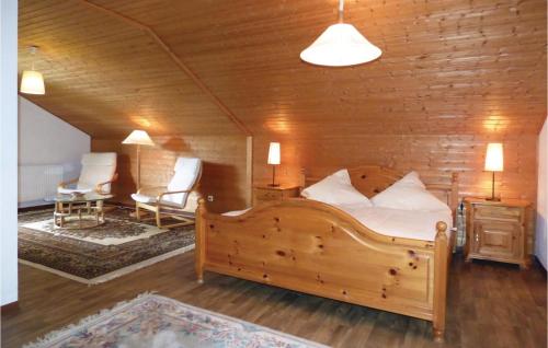 a bedroom with a wooden bed and two chairs at Ferienhaus 17 In Thalfang in Thalfang