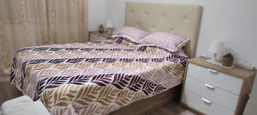 a bedroom with a bed with a comforter and pillows at CasaBarreiro in Barreiro