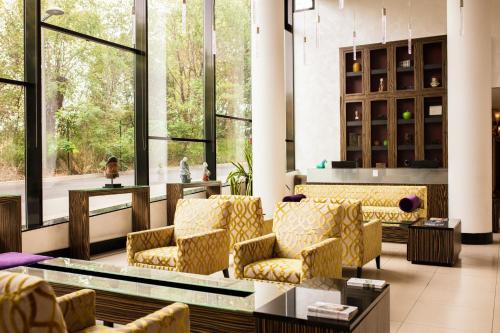 a lobby with yellow chairs and a table and windows at Radisson Blu Hotel, Montpellier in Montpellier