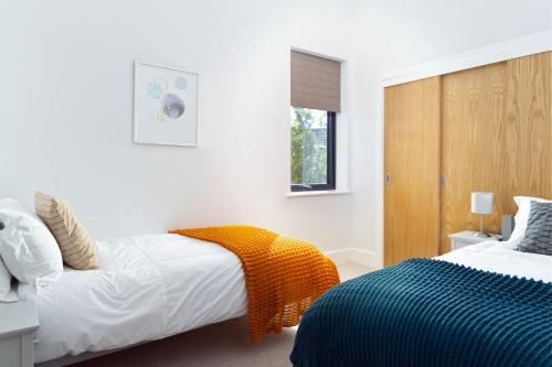 een slaapkamer met 2 bedden en een raam bij Lakeside property with spa access on a nature reserve Maple House BV08 in Warmwell