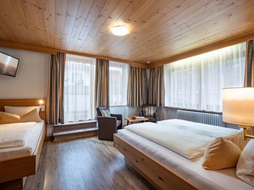 una habitación de hotel con una cama grande y una silla en Gästehaus Knunbauer, en Mayrhofen