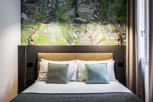 a bedroom with a bed with a large painting on the wall at Design Club Collection in Bologna