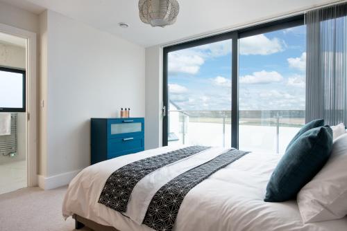 a bedroom with a bed and a large window at Luxury property with access into Spa on a nature reserve Beaumont Village 14 in Warmwell