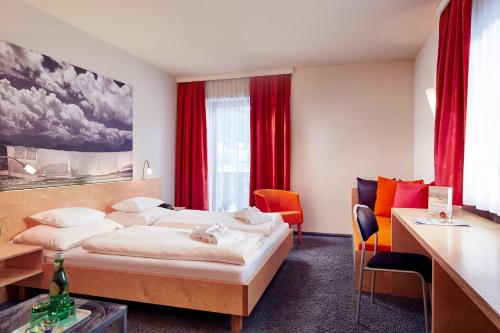 a hotel room with a bed and red curtains at Loisach Smarthotel by keyone in Lermoos
