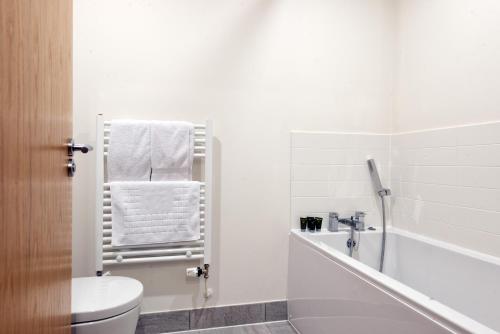 Somerford KeynesにあるLakeside property with spa access on a nature reserve Pochard HM109のトイレと浴槽を備えた白いバスルーム