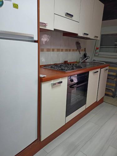 a kitchen with white cabinets and a stove top oven at NICE CORNER in Koper