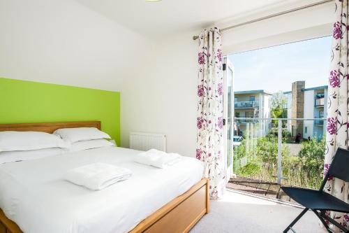 une chambre avec un lit et une grande fenêtre dans l'établissement Lakeside property with access into Spa on a nature reserve Bee Cottage HM75, à Somerford Keynes