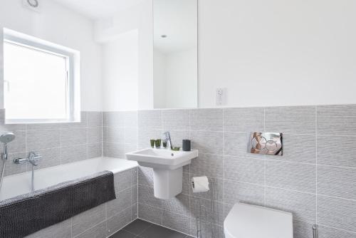 une salle de bain blanche avec un lavabo et des toilettes dans l'établissement Lakeside property with spa access on a nature reserve Swans Rest HM103, à Somerford Keynes
