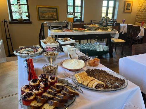 a table filled with different types of pastries and desserts at Gioraldi Art Hotel in Ano Pedina