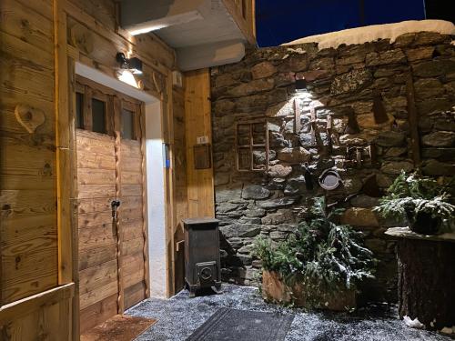 a room with a stone wall and a stove at Maison Rongier nel centro di Cogne in Cogne