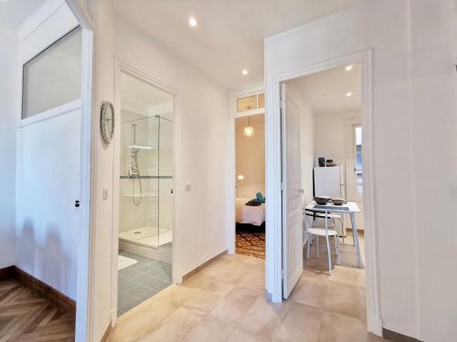 - un couloir avec une porte en verre menant à une salle de bains dans l'établissement Le FOCH2 by Booking Guys, à Villefranche-sur-Mer