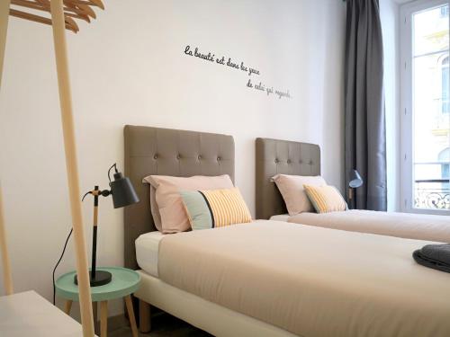 dos camas sentadas una al lado de la otra en un dormitorio en Appartement Urban 3, en Niza