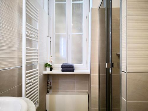 La salle de bains est pourvue d'une fenêtre, d'un lavabo et d'une douche. dans l'établissement Appartement Urban 3, à Nice