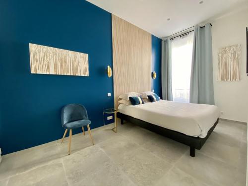 ein Schlafzimmer mit einem Bett und einer blauen Wand in der Unterkunft Appartement Urban 5 in Nizza
