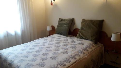 a bedroom with a bed with a blue and white comforter at Casavacanze Abetone in Abetone