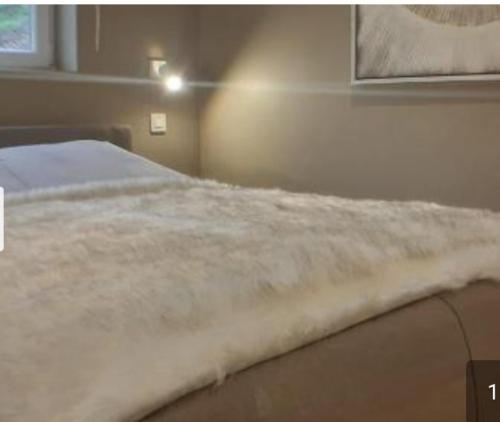 ein Schlafzimmer mit einem Bett mit einer weißen Decke in der Unterkunft Terrasses de Malmedy Lodge 417 in Malmedy