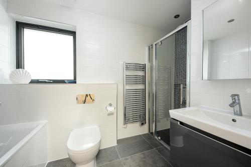 Luxury property with spa access on a nature reserve Hambury Cottage BV22 في Warmwell: حمام ابيض مع مرحاض ومغسلة