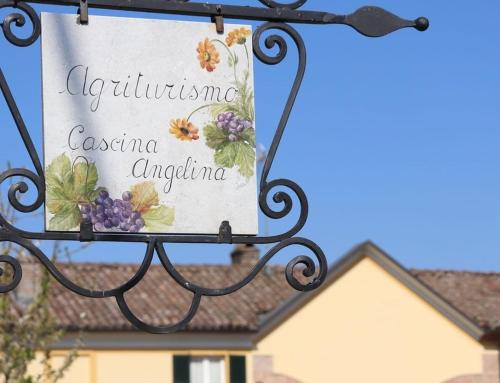 a sign hanging from a wrought iron holder in front of a house at Cascina Angelina in Casteggio