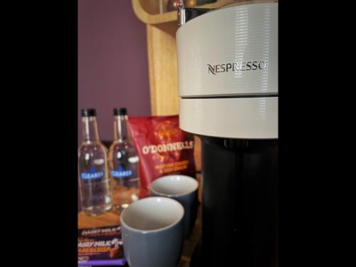 a coffee maker sitting on top of a table with bottles of wine at Lough Rooms at The Artisan in Strangford