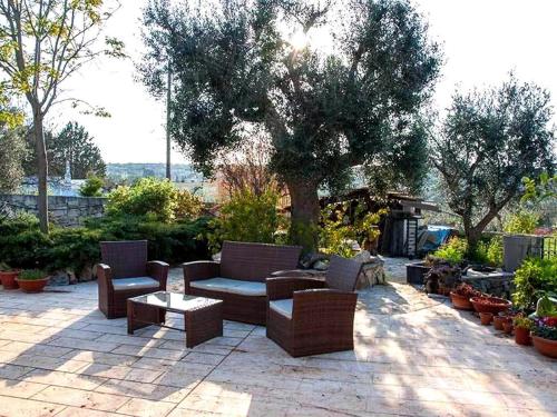eine Terrasse mit Sofas, Stühlen und einem Tisch in der Unterkunft Casale Romanazzi Pool & Nature in Monopoli