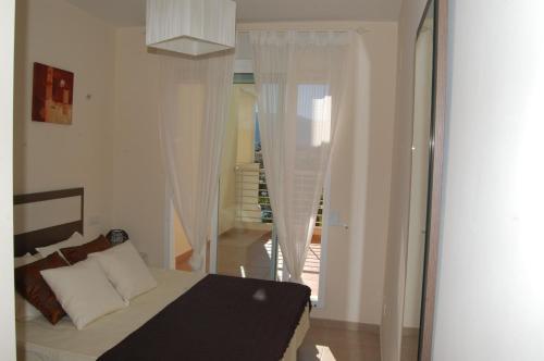 une chambre avec un lit et une pièce avec une fenêtre dans l'établissement Coll Verd Apartment, à Dénia