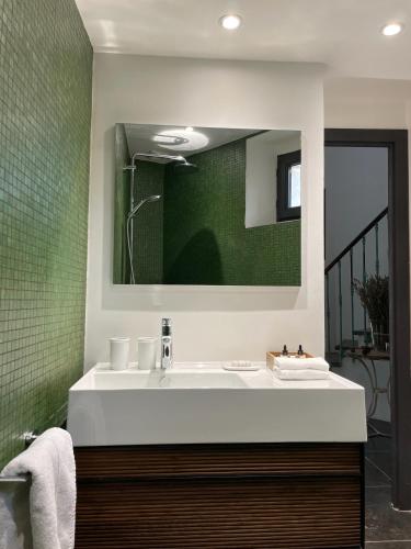 une salle de bain avec un lavabo blanc et un miroir dans l'établissement Le Pavillon Du Regisseur, à Val-de-Dagne