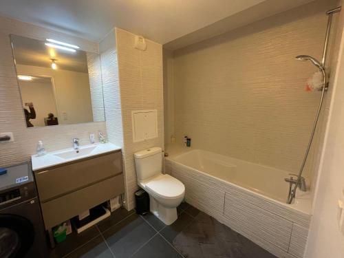 une salle de bain avec toilettes, baignoire et lavabo dans l'établissement Superbe appart avec vue panoramique sur La Défense, à Bois-Colombes